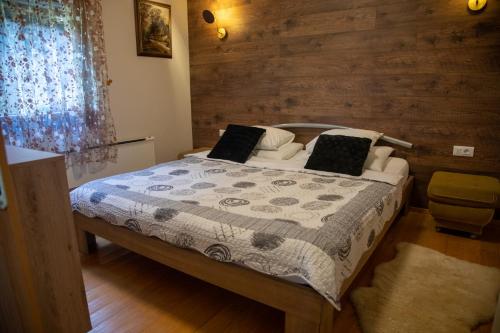 Brestova DragaKuća za odmor Gorski Kotar的一间卧室设有一张床和木墙