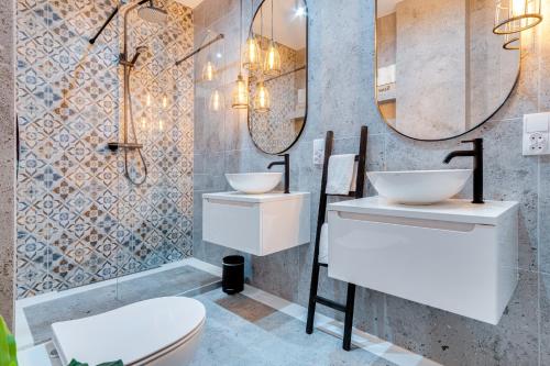 弗罗茨瓦夫Modern Italia Apart - 100m Main Square - parking and lift的一间带两个盥洗盆和卫生间的浴室