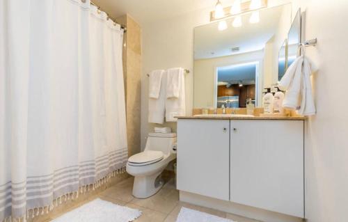 波因顿海滩Tropical Coastal Resort的一间带卫生间、水槽和镜子的浴室