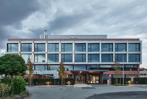 AndelfingenAutohalle Hotel的一座大型办公楼,有很多窗户