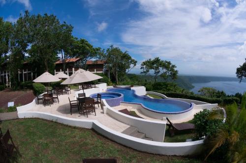 La LagunaPacaya Lodge and Spa的一个带游泳池和桌椅的度假酒店