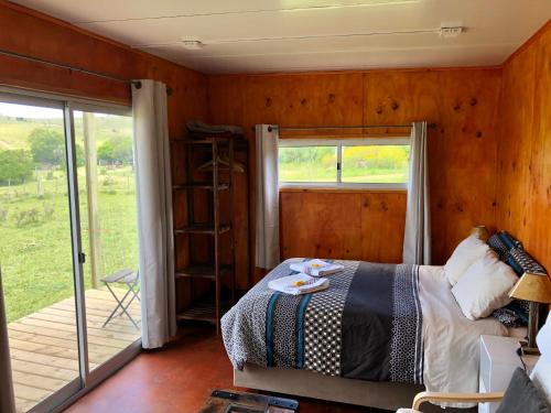 米纳斯Bungalow de campo Nabucco - sierras, naturaleza y descanso的一间卧室设有一张床和一个滑动玻璃门