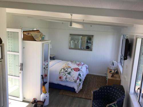 陶朗加Sunset Cottage的一间小卧室,配有一张床和镜子