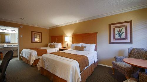 米尔布雷SFO El Rancho Inn SureStay Collection by Best Western的酒店客房设有两张床和一张桌子。