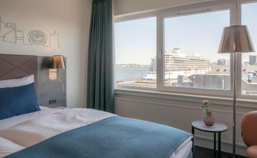 奥尔堡奥尔堡利姆海峡丽笙酒店的酒店客房设有一张床和一个带游轮的窗户