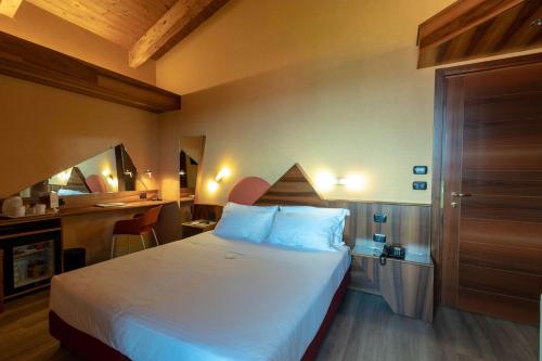 伊夫雷亚La Villa - Sure Hotel Collection by Best Western的配有一张床和一张书桌的酒店客房