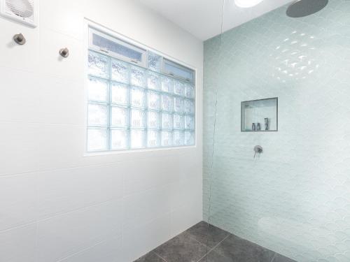 扬巴Pippi Sands LJHooker Yamba的带淋浴的浴室和窗户