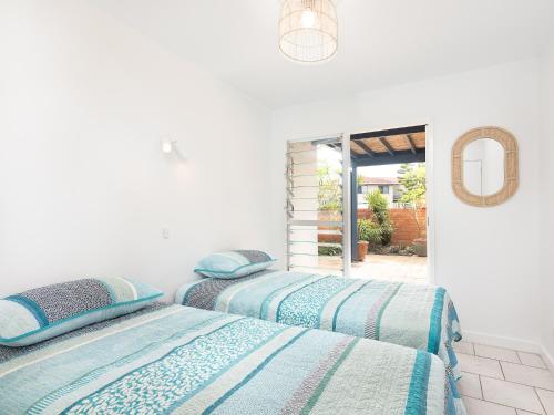 扬巴Pippi Sands LJHooker Yamba的白色客房的两张床,设有窗户