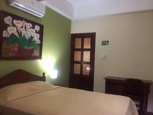 莱昂Hotel Vizcaíno León的一间卧室配有一张床,并装饰有鲜花