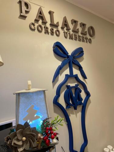 BoianoBoutique Hotel Palazzo Corso Umberto的墙上有两根蓝色的弓,上面有标志