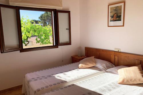 圣弗朗西斯科哈维尔Aptos rurales Can Pep de Sa Barda - Viñedos y tranquilidad的一间卧室设有一张床和一个窗口