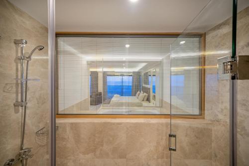 科纳克勒ARIA RESORT & SPA HOTEL Ultra All Inclusive的带淋浴的浴室和玻璃窗