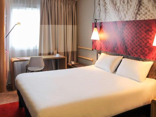 拉特斯特德布赫拉特斯特布赫阿尔卡松宜必思酒店的酒店客房设有一张大床和一张书桌。