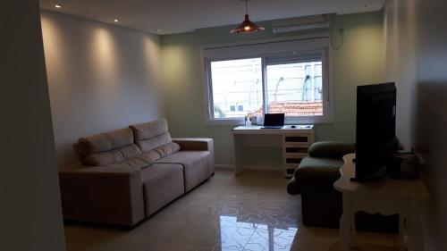 阿雷格里港Manacá House Porto Alegre的带沙发和窗户的客厅