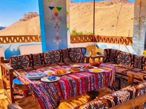 阿斯旺Nubian Kingdom Aragheed House的一张沙发,上面有一张桌子和盘子