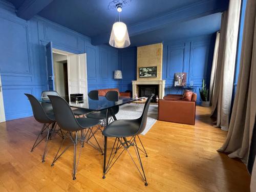 圣艾米隆La Petite Fontaine的一间拥有蓝色墙壁和桌椅的用餐室
