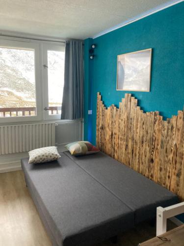 拉姆吉Studio mongie aux pieds des pistes avec balcon的蓝色墙壁间的一张床位
