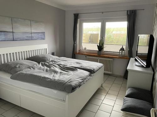 腓特烈斯科格Freundliche Ferienwohnung direkt hinter dem Deich的一间卧室设有一张床和一个窗口