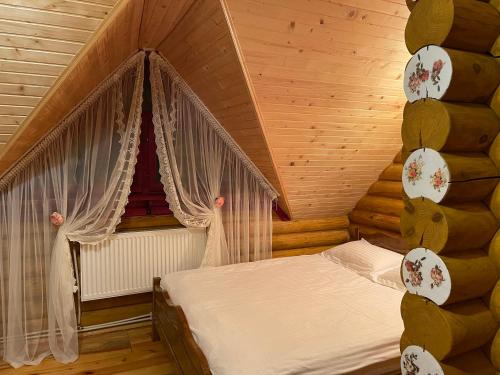 亚布卢尼齐亚Еко котедж Яблуницька троянда的木制客房内的一间卧室,配有一张床
