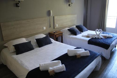 尚塞拉德德拉贝隆酒店的两张位于酒店客房的床,配有毛巾