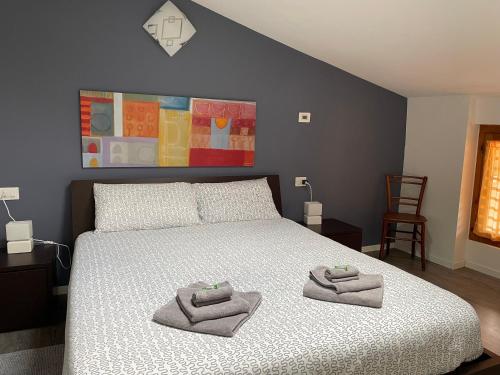 加尔达湖滨Relax Suite Holiday Apartment的一间卧室配有一张床,上面有两条毛巾