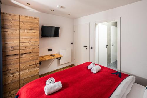 卡普伦Falcon Suites Kaprun的一间卧室配有红色的床和毛巾