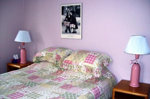 拉马巴耶拉美好时代酒店的一间卧室配有一张带两盏灯的床,墙上挂着一张照片