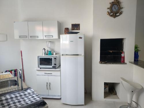 南圣洛伦索Apartamento BLUE 04 - 100 metros da praia的白色的厨房配有冰箱和微波炉。