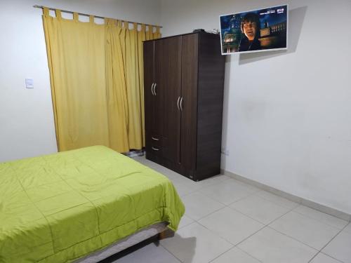 圣胡安Departamento Monoambiente Rivadavia的一间卧室配有一张床,墙上配有电视