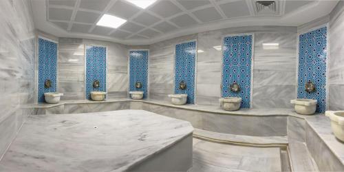 DerekoyES TERMAL OTEL&SPA的白色浴室设有4个卫生间和蓝色窗户