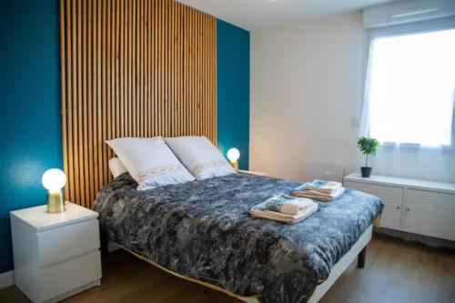 图尔LES 2 LIONS moderne confort proche transports的一间卧室配有一张床,上面有两条毛巾