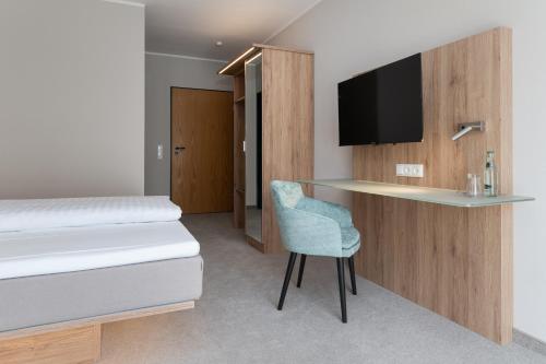 比克堡Hotel Grosse Klus的客房设有一张床、一张书桌和电视