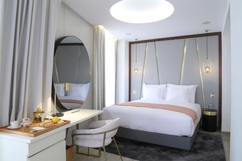 里斯本São Vicente Alfama Hotel by TRIUS Hotels的一间卧室配有一张床、一张书桌和一面镜子