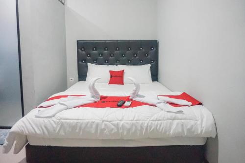 RampalRedDoorz Plus @ Kalpataru的一间卧室配有一张红色枕头的床