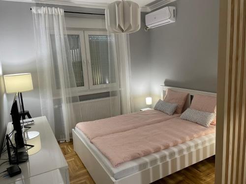松博尔Apartmani Sombor的一间卧室设有一张大床和一个窗户。