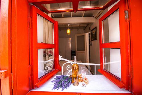 恰纳卡莱Grape Island Bozcaada Guest House的一张桌子,里面装有两个红色的窗户
