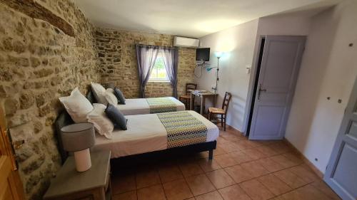 叙兹拉鲁斯La Bastide Saint Bach的一间卧室设有一张床和砖墙