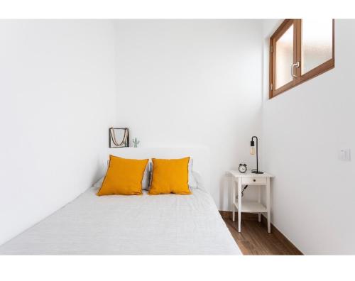 布埃纳维斯塔德尔诺尔特La Casita de Juana的白色客房内的白色床和橙色枕头