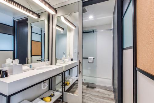 阿林顿Aloft Dallas Arlington Entertainment District的一间带两个盥洗盆和淋浴的浴室