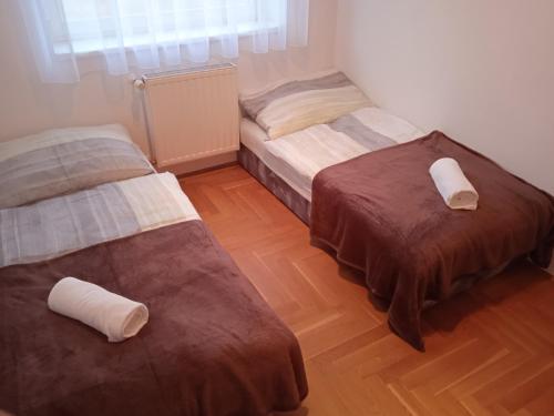 杰尔Family apartment-családias hangulat的铺有木地板的客房内的两张床
