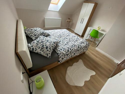锡吉什瓦拉B&B Home的一间小卧室,配有一张床和一把绿色椅子