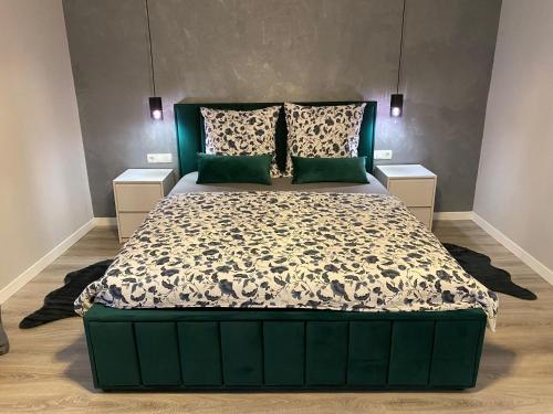 锡吉什瓦拉B&B Home的一间卧室配有一张大床和绿色床头板