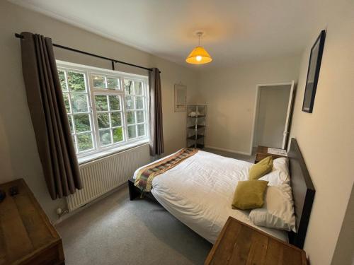 内尔斯沃思Garden House的一间卧室设有一张床和一个窗口