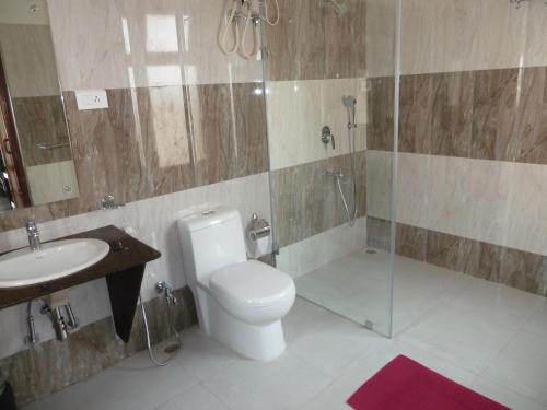 KumguriMusa Jungle Retreat的浴室配有卫生间、淋浴和盥洗盆。