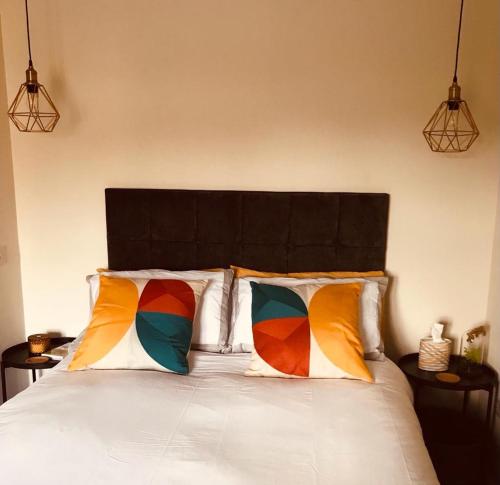 斯特灵The TollHouse的一间卧室配有一张带两个色彩缤纷的枕头的床