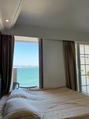 香港海景度假屋的一间卧室配有一张床,享有海景