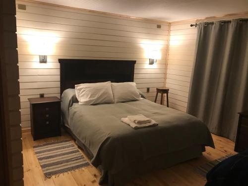 Villa O'HigginsCasa Rural 32的一间卧室配有一张床,上面有两条毛巾