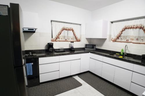 奥拉涅斯塔德Aruba Vacation House - Cozy and Modern!的厨房配有白色橱柜和黑色台面