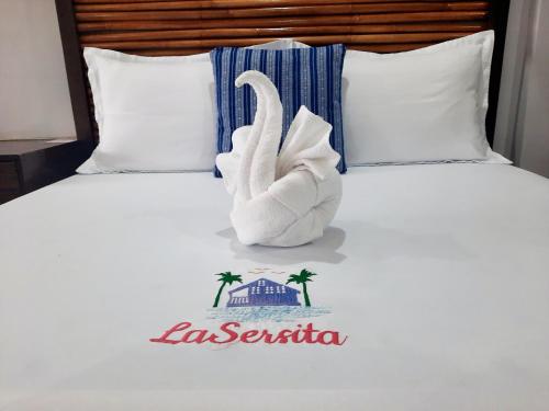 LaSersita Casitas and Water Spa Beach Resort by Cocotel的床上的毛巾天鹅,名字叫度假村