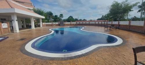 瓜拉丁加奴瓜拉丁加奴高尔夫爱卡萨度假村的一个带房子的庭院中的游泳池